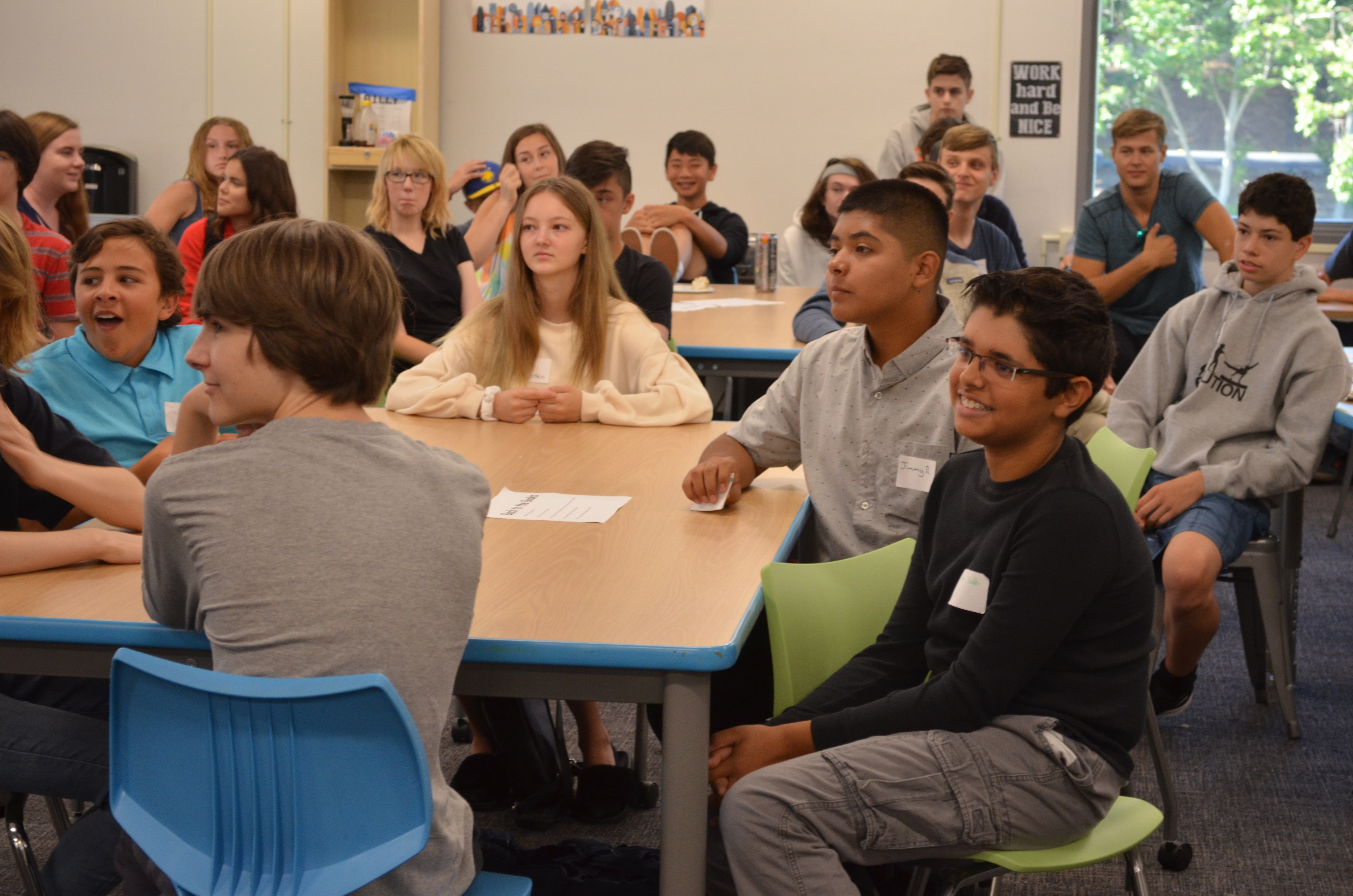 Students sit around tables and listen during Orientation Day at Quest Forward Academy Santa Rosa.