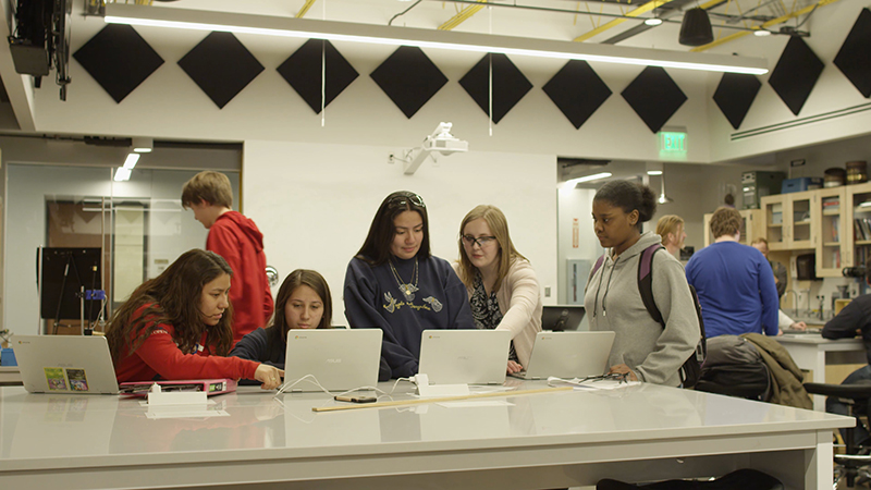Students and a mentor work intently in Quest Forward Academy Omaha's state-of-the-art science lab.