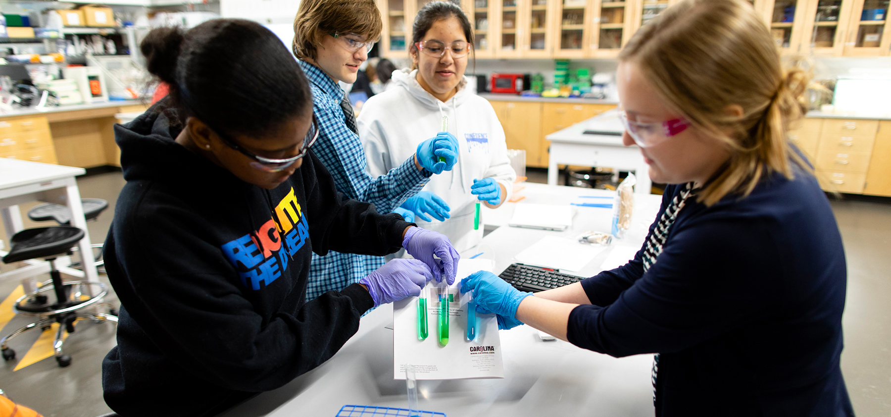 Students compare test tubes in the Bellevue lab at Quest Forward Academy Omaha.