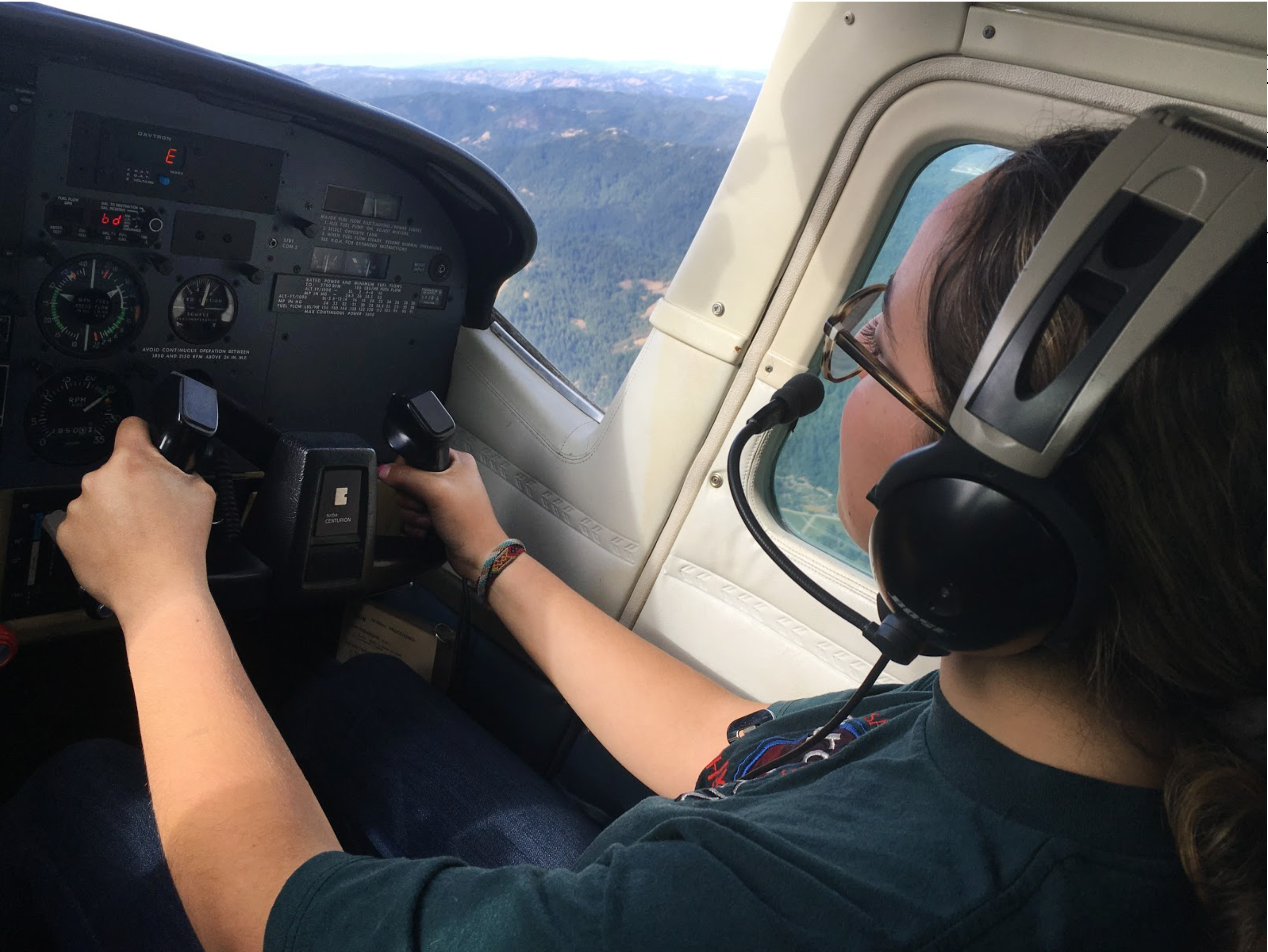 A student in the cockpit of a plane during an internship, with the Sonoma landscape visible through the window.