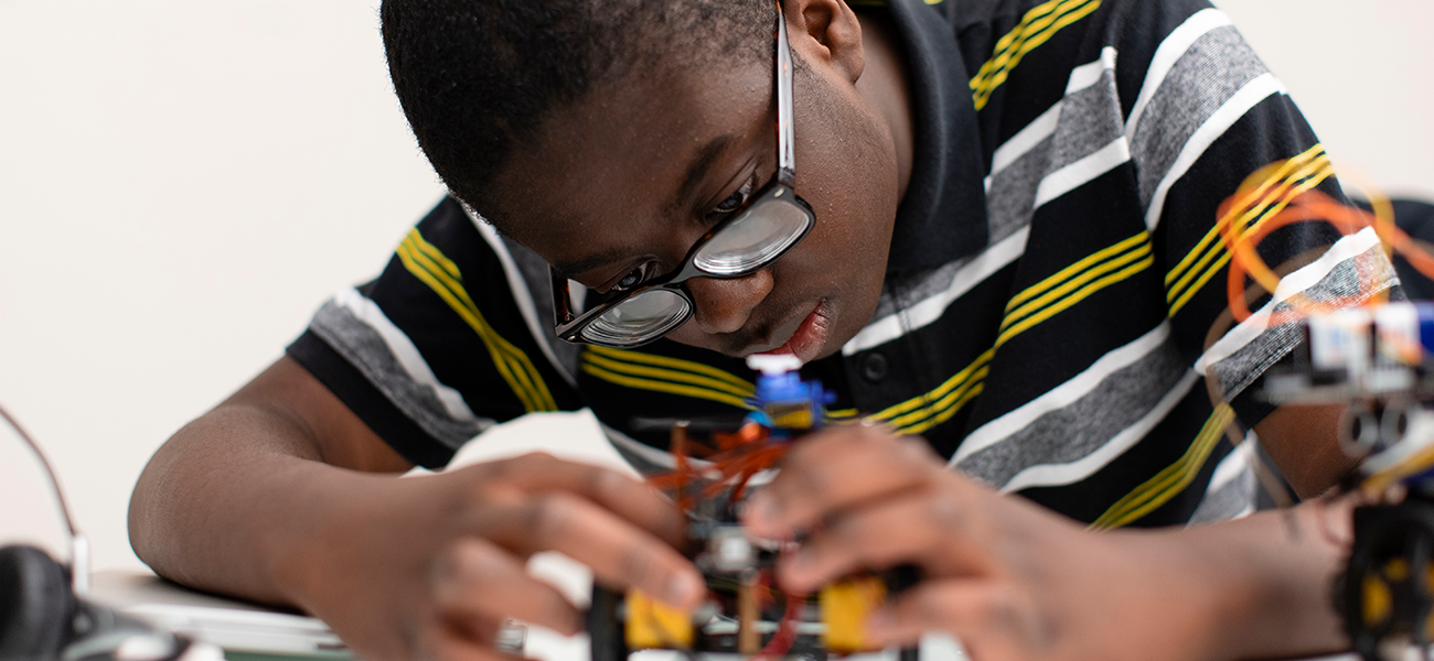 A boy focuses on a robotics project