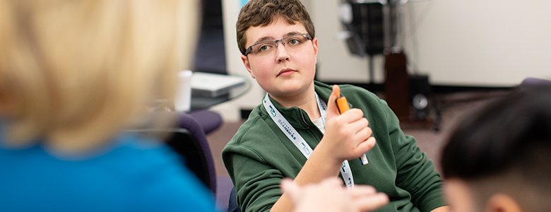 A student at Quest Forward Academy Omaha focuses on his teacher as she gives him feedback.